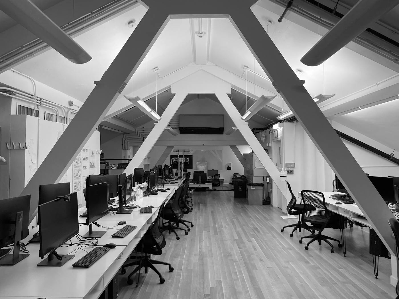 Black and white technology workspace with monitors and desks
